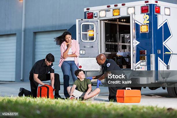 Foto de Paramedics Ajuda Um Menino Com Sua Mãe Observa e mais fotos de stock de Criança - Criança, Paramédico, Serviço de emergência e resgate