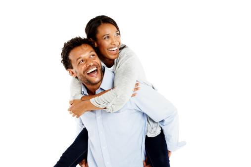 Portrait of mature man carrying his girlfriend on his back looking away laughing against white background