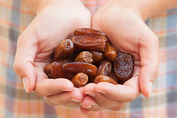 Dates in woman's palms Dates in woman's palms. date fruit stock pictures, royalty-free photos & images