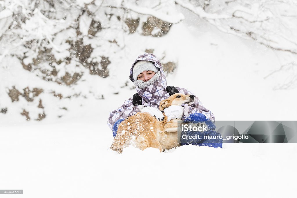 Woman playing with her dog during a Snowfall Woman playing with her dog during a Snowfall. Copy space. Adult Stock Photo