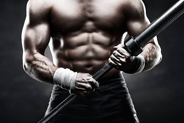 istock Shadowed muscular man holding a bar for body building 452647689