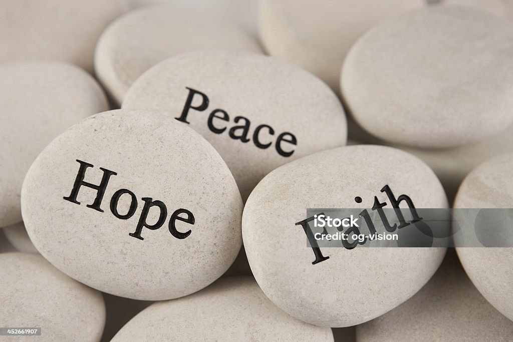 Inspirational stones Close up of stones with engraved words Hope, Faith, Peace Abstract Stock Photo