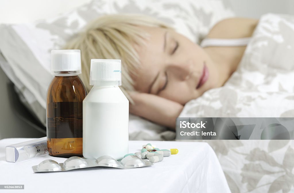 cold and flu sick girl sleeping in bed Adult Stock Photo