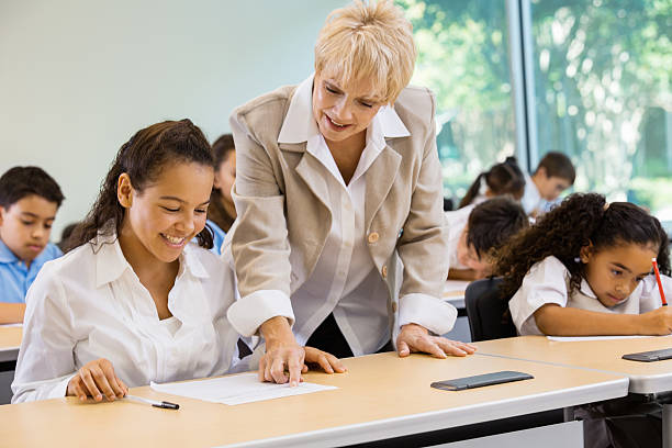 istock Senior teacher tutoring students in private school 452669363
