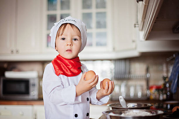 istock Little boy, dressed like cook, baking muffins 452670311