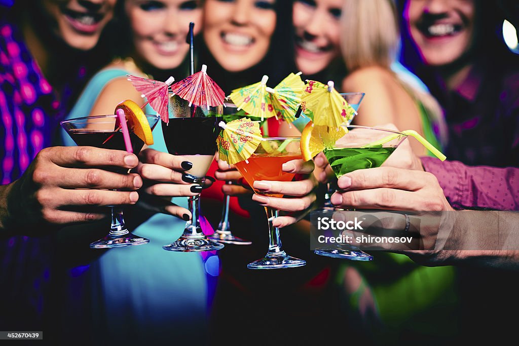 Toasting Glasses with cocktails held by happy friends at party Adult Stock Photo