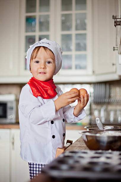 istock Little boy, dressed like cook, baking muffins 452678635