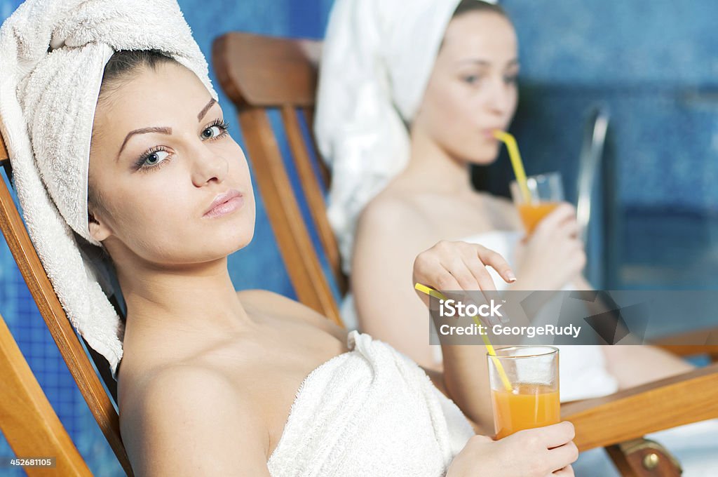 Spa & Wellness Spa & Wellness. Girls in bathrobe drinking juice in spa salon Adult Stock Photo