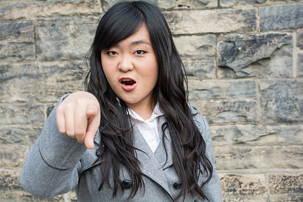 Angry woman by a stone wall stock photo