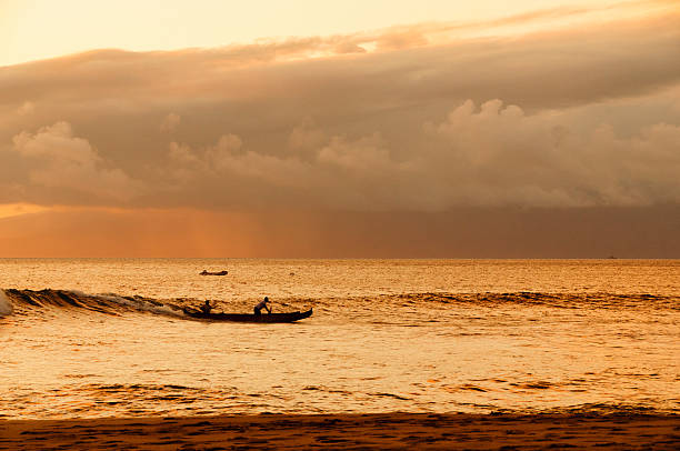 istock Two men paddling a Hawaiian outrigger canoe at sunset. 452681733