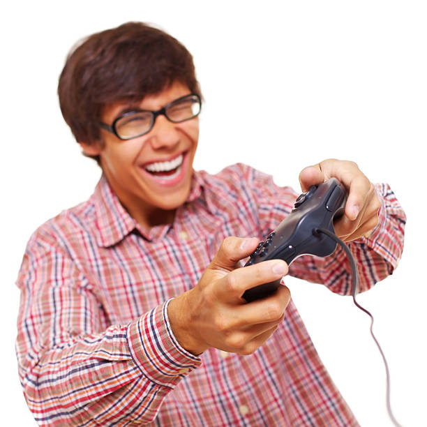 Happy laughing teenager in glasses playing video game by joystick. Isolated on white background, focus on joystick