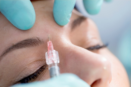 Treatment with hyaluronic acid and lidocaine. Used for  facial tissue agumenation, wrinkles correction and lip enhancement. On this image the doctor is usin the syringe on the patient skin.