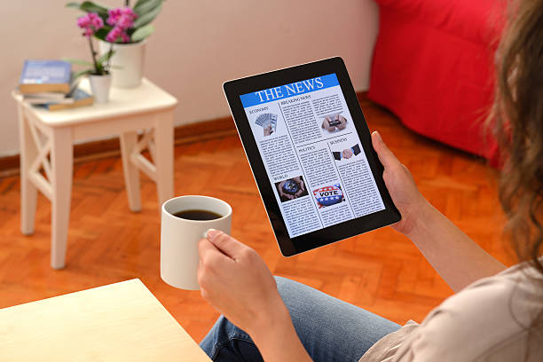 istock Woman reading news on tablet pc 452696527