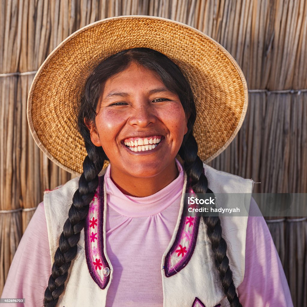 Portrait of happy woman on Uros floating island, Lake Tititcaca Uros are a pre-Incan people that live on forty-two self-fashioned floating island in Lake Titicaca Puno, Peru and Bolivia. They form three main groups: Uru-Chipayas, Uru-Muratos  and the Uru-Iruitos. The latter are still located on the Bolivian side of Lake Titicaca and Desaguadero River. The Uros use bundles of dried totora reeds to make reed boats (balsas mats), and to make the islands themselves. The Uros islands at 3810 meters above sea level are just five kilometers west from Puno port.http://bem.2be.pl/IS/peru_380.jpg Peru Stock Photo