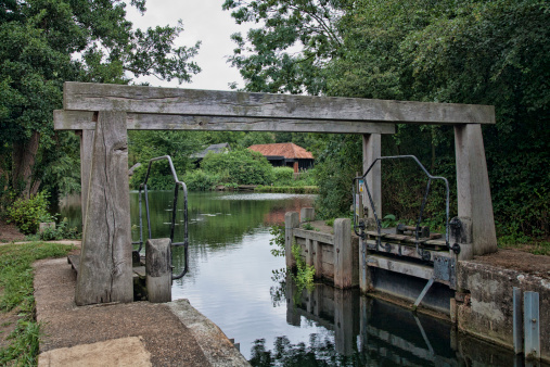 Flatford Lock, located on the River Stour.  The locks along the Stour have horizontal lintels above the water to prevent the locks from caving in.  These lintels are unique to locks on the Stour.  This lock is near the Hamlet of Flatford, near East Bergholt in Suffolk, United Kingdom.  This part of Suffolk is famous at the place where John Constable, the famous nineteenth century painter, did a number of his landscape paintings,