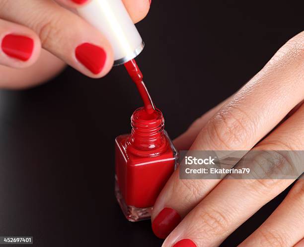 Bottiglia Di Rosso Di Smalto In Mano Donna - Fotografie stock e altre immagini di Adulto - Adulto, Aperto, Aprire