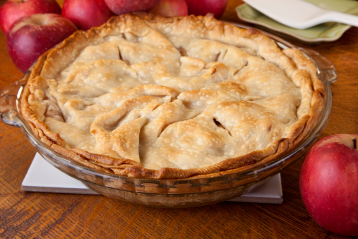 Fresh baked homemade apple pie surrounded by apples on a table ready to eat. Image shot with Canon 5D Mark2, 100 ISO, 24-115mm lens, studio strobes.