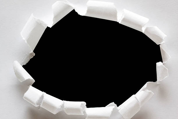 istock Torn paper hole background isolated on black 452699189