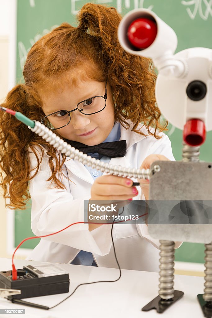 Education:  Retro revival scientist in lab.  Electronics. Retro revival image of child scientist in lab working on the arms of a robot that she is building.   1940-1949 Stock Photo