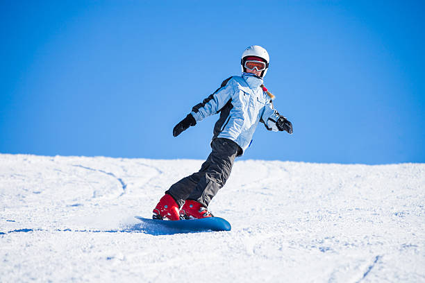 adolescente snowboarding on sunny winter día - snowboarding snowboard women teenager fotografías e imágenes de stock