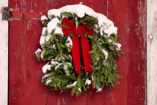 Christmas Wreath on Red Barn Door, covered with fresh snow, horizontal format, perfect for Christmas Card
