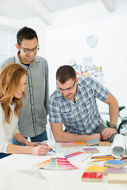 istock Young Architects review blueprints at office. 452702219