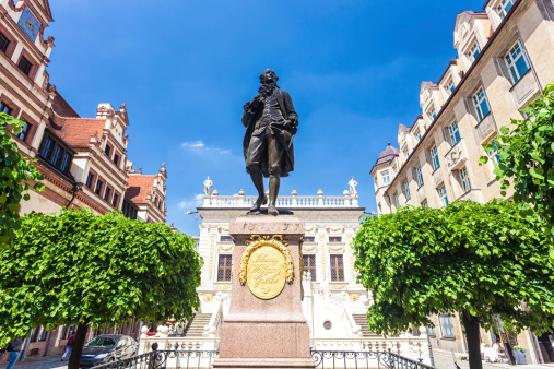 Dusseldorf, Germany-April 2022; Low angle view of bronze statue in center of the city market square of John William, one of the founders of the city in the Old Town with historic town hall in back