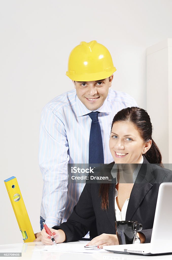 Trabajo en equipo en la oficina moderna con ingeniero con casco y mujer de negocios - Foto de stock de Administrador libre de derechos