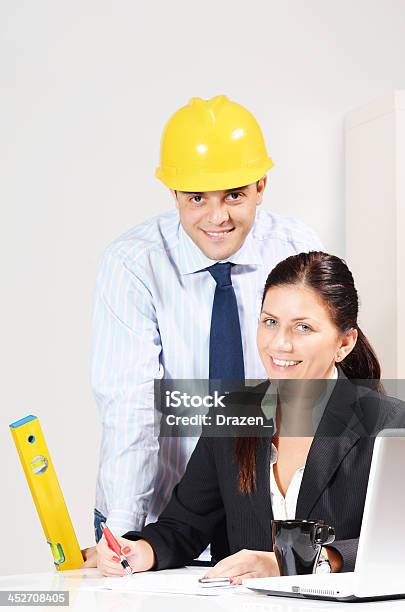 Trabajo En Equipo En La Oficina Moderna Con Ingeniero Con Casco Y Mujer De Negocios Foto de stock y más banco de imágenes de Administrador