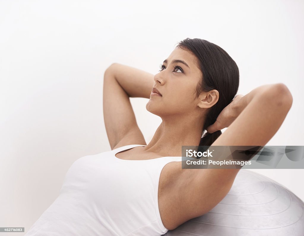 All important core exercises A young woman doing sit-ups using a pilates ball 20-24 Years Stock Photo