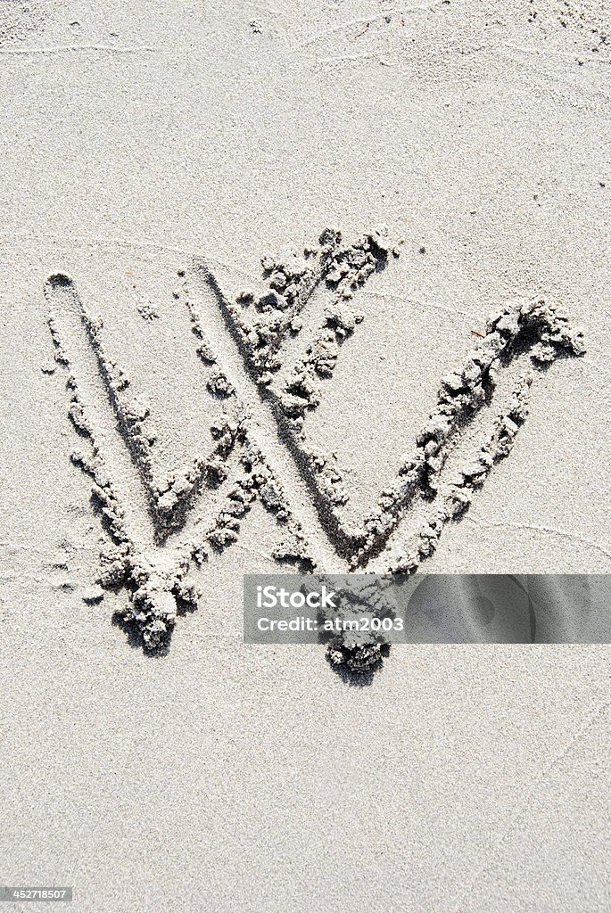 Sand beach alphabet: letter W The letter W of the alphabet writing on the sand beach Alphabet Stock Photo