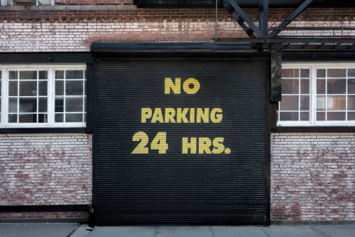 No Parking sign on steel garage door.