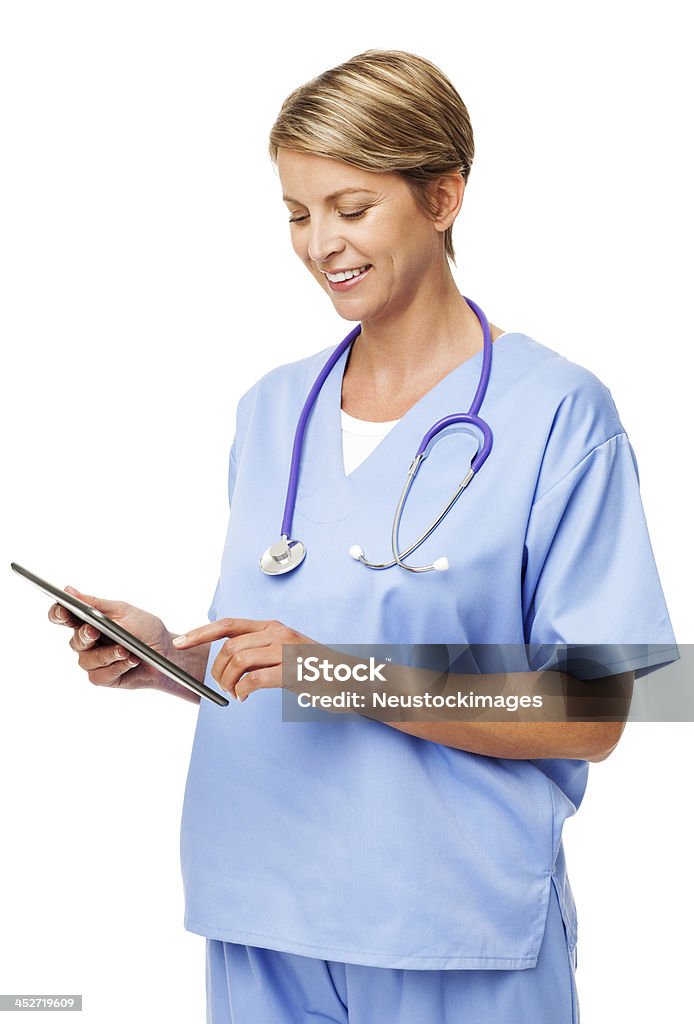 Nurse With Stethoscope Around Neck Using Digital Tablet Smiling mid adult nurse with stethoscope around neck using digital tablet against white background. Vertical shot. Looking Stock Photo