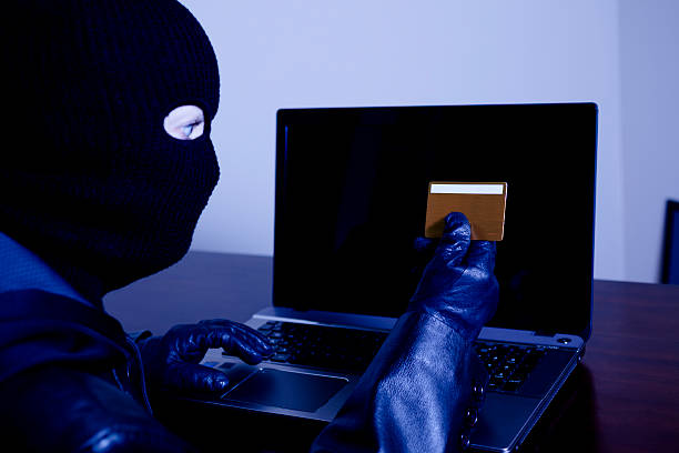 istock Cyber crimes. Thief steals credit card information in office. 452720405