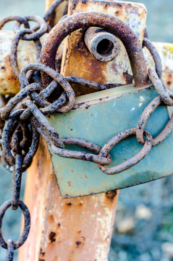 old rusty padlock holding chain