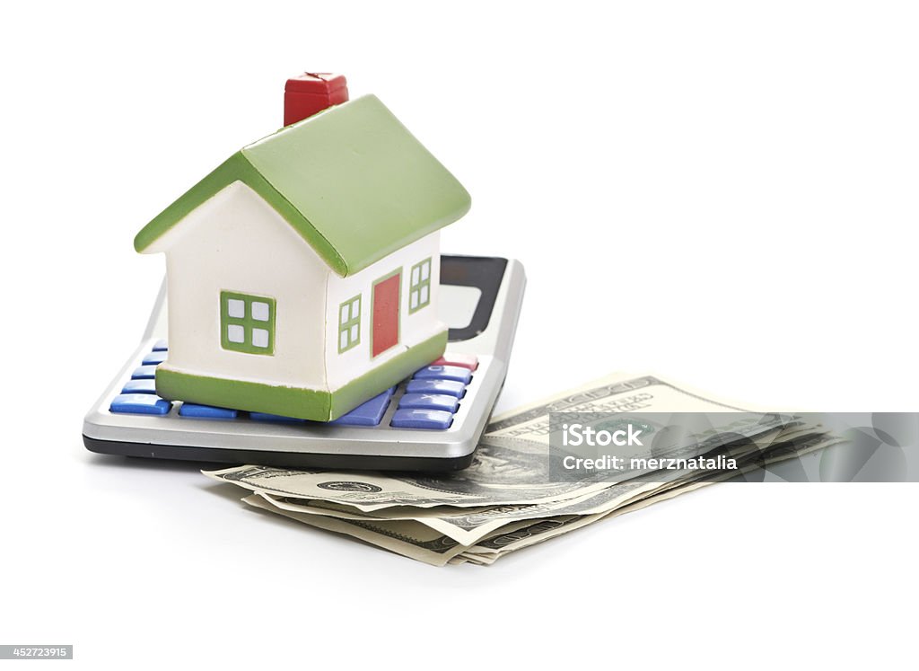 house sitting with a calculator and dollar Backgrounds Stock Photo