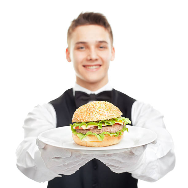 istock Young happy smiling waiter holding hamburger on plate 452724599