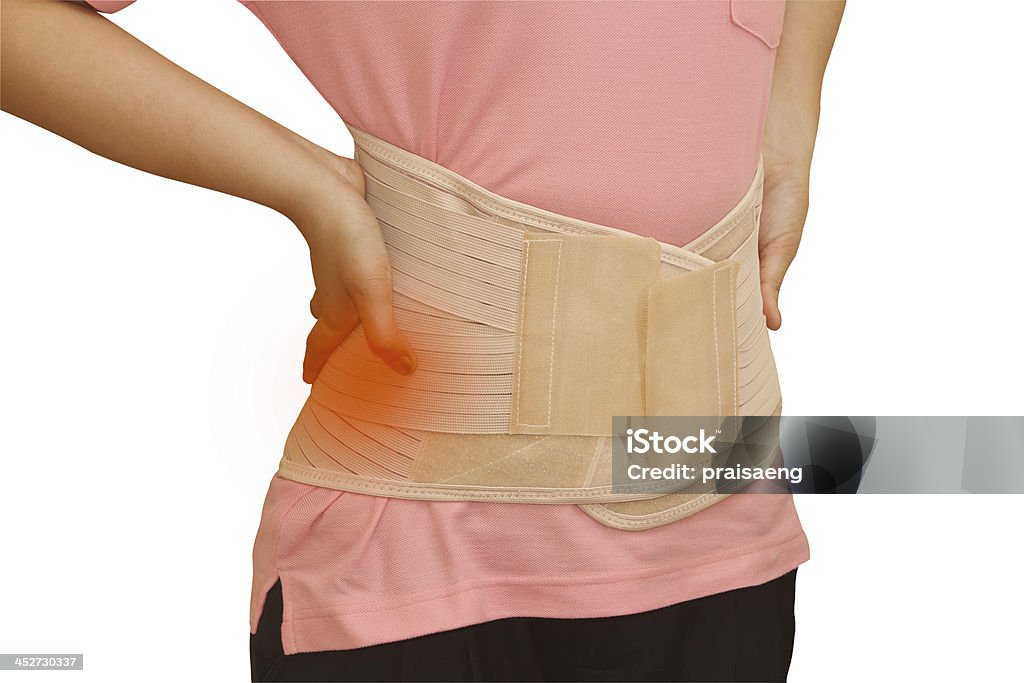 Mujer en dolor de la lesión en la espalda lleva corsé corsé lumbar - Foto de stock de Adulto libre de derechos