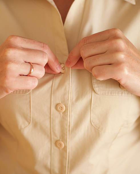 istock Woman buttoning her beige shirt 452742663