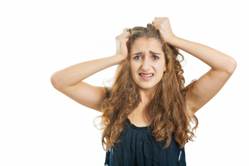 Teenage Girl with beautiful long curly hair. She looks frustrated and annoyed.