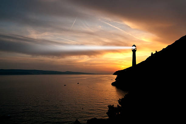 Lighthouse searchlight beam through marine air at night