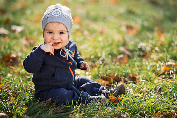 istock little boy sitting on the grass 452743507