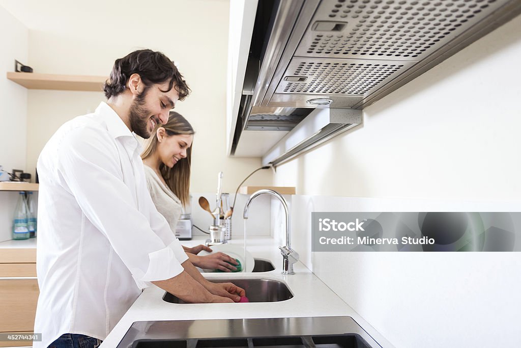 Young couple doing dishes Young couple doing dishes in the kitchen Adult Stock Photo