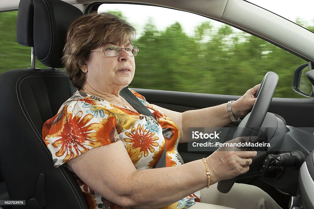 Mujer mayor conducir un coche - Foto de stock de Interior del coche libre de derechos