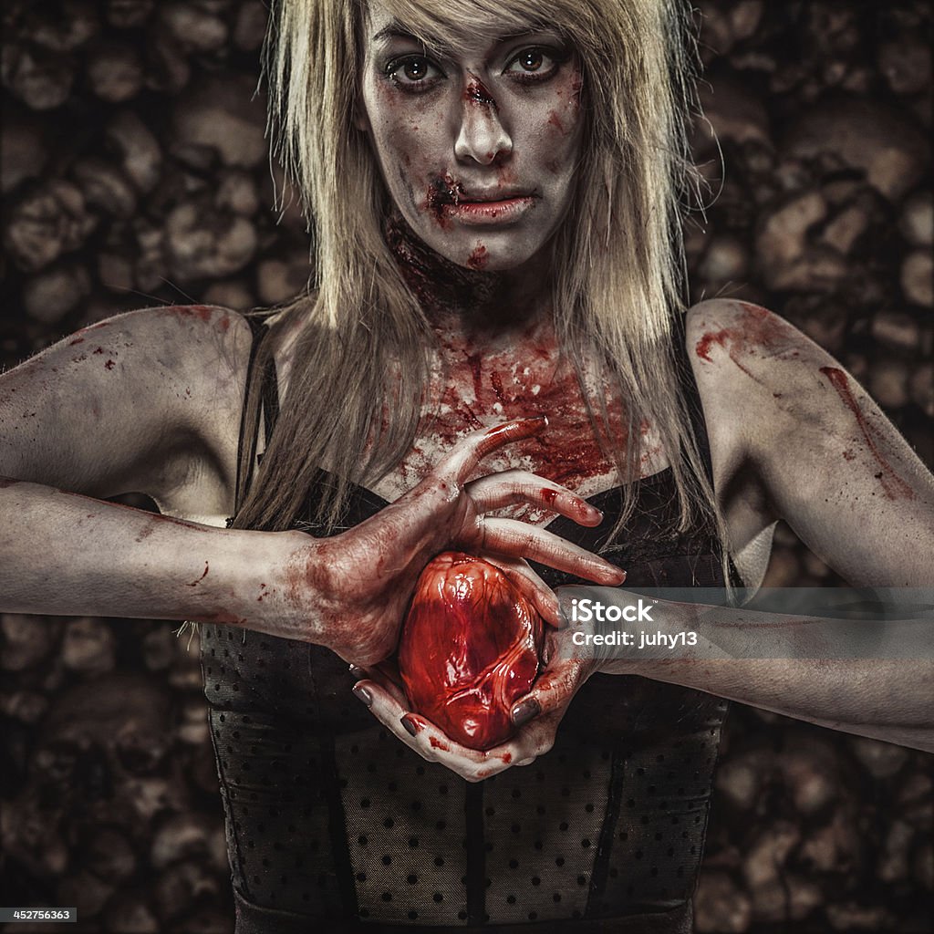 Young Zombie Woman Holding a Human Heart Young Zombie/Vampire holding a human's Heart Horror Stock Photo