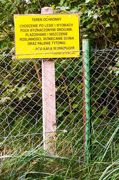 An image of fencepost and empty yellow signboard