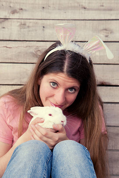 istock Beautiful young woman as easter bunny with a white rabbit 452763847