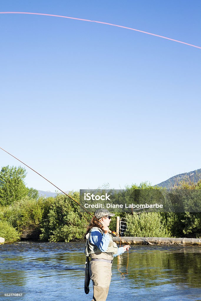 Donna Pesca A mosca con una montagna di vapore - Foto stock royalty-free di Acqua