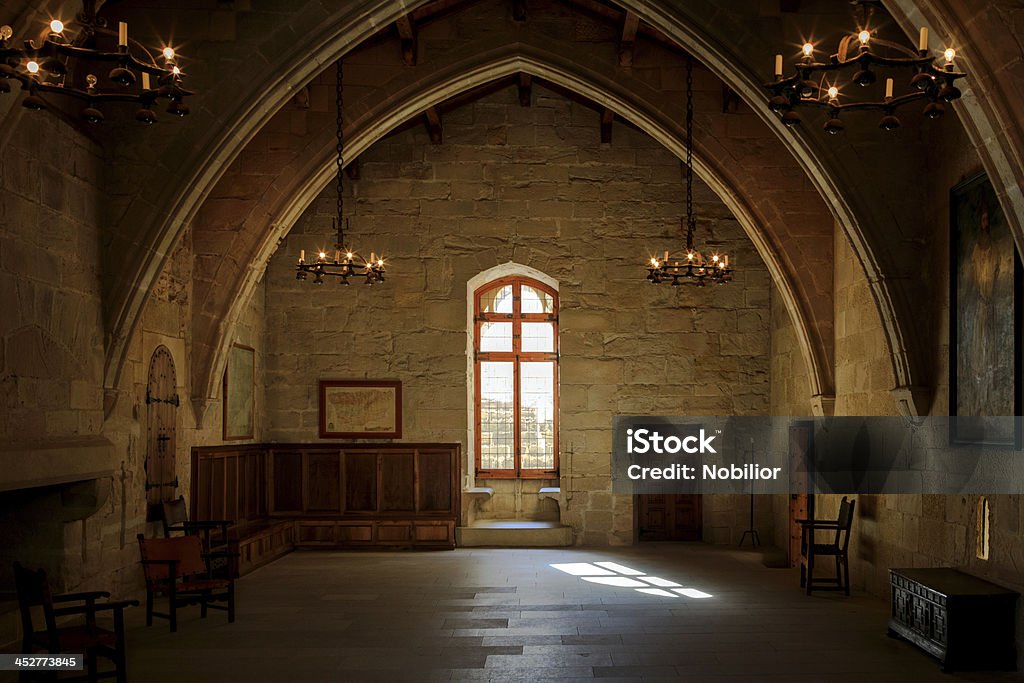 Dark old room Dark old room in Poblet cloister with stained glass window and candelabra, Spain Castle Stock Photo