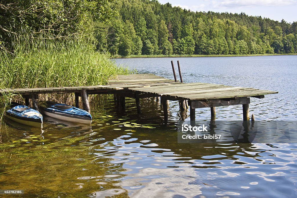 jetty e canoas no lago em Masuria, Polônia - Foto de stock de Lago royalty-free